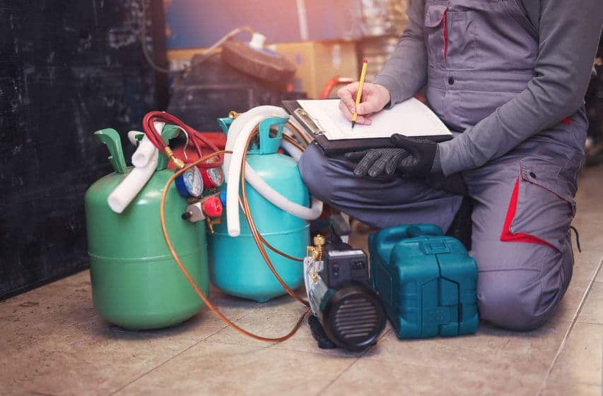 air-conditioning-technician-checking-his-tanks-holding-refrigerants